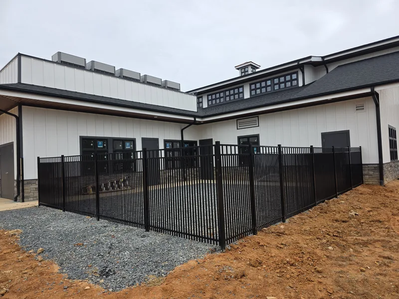 Black aluminum fence around a commercial building yard