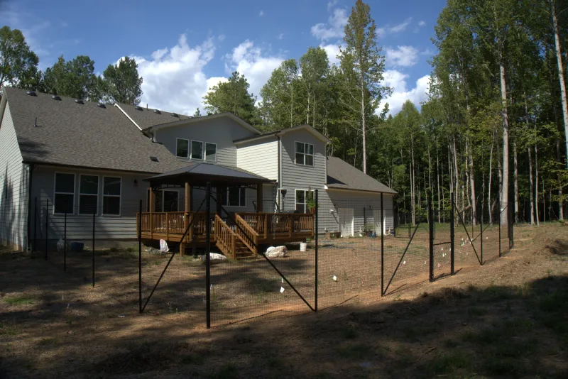 Finished black mesh fence around the back yard of the same home