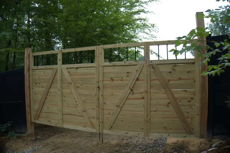 Wood privacy fence with a double drive gate and top rail details